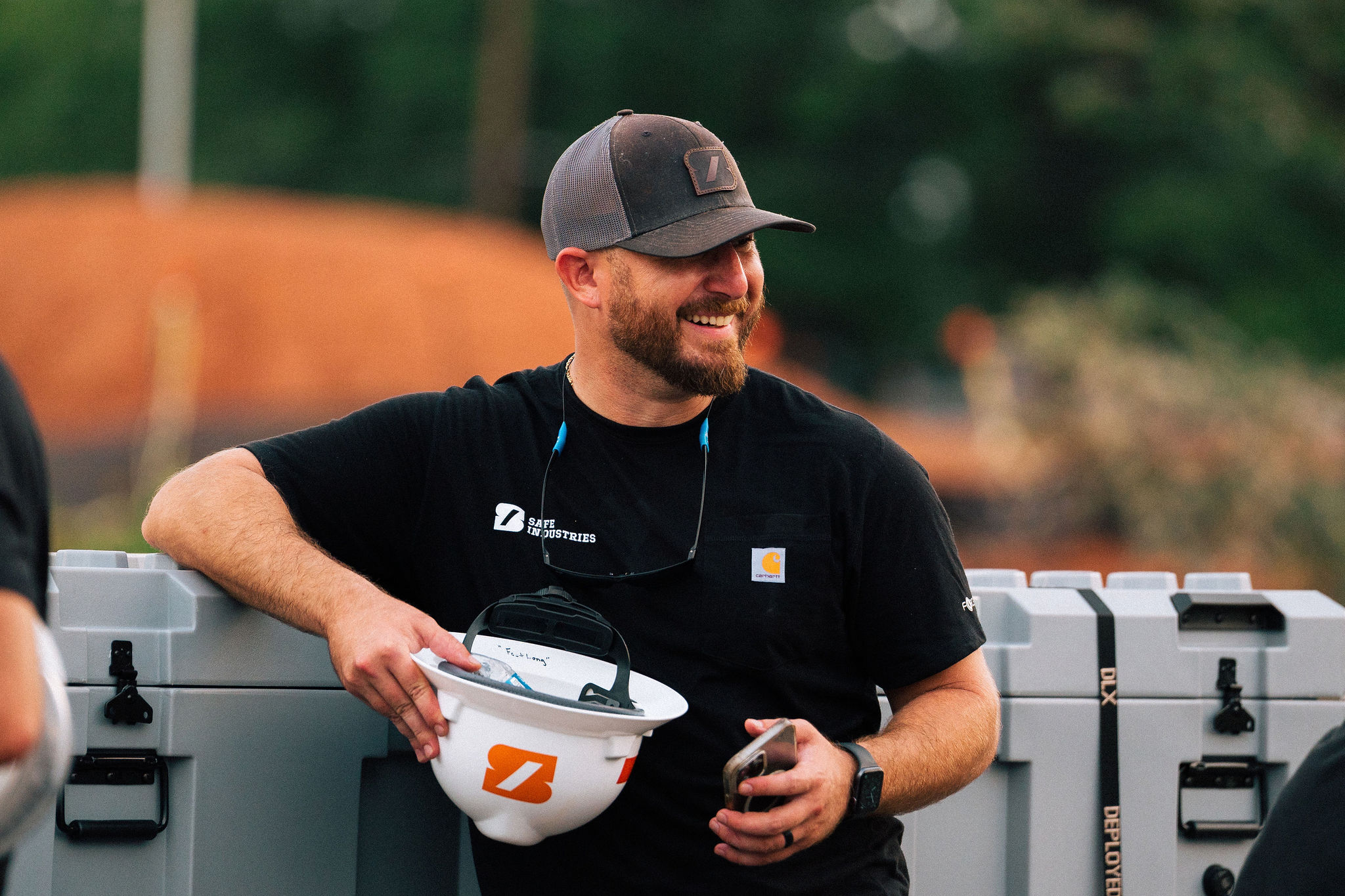 A team member laughing beside deployment cases on an emergency response staging site