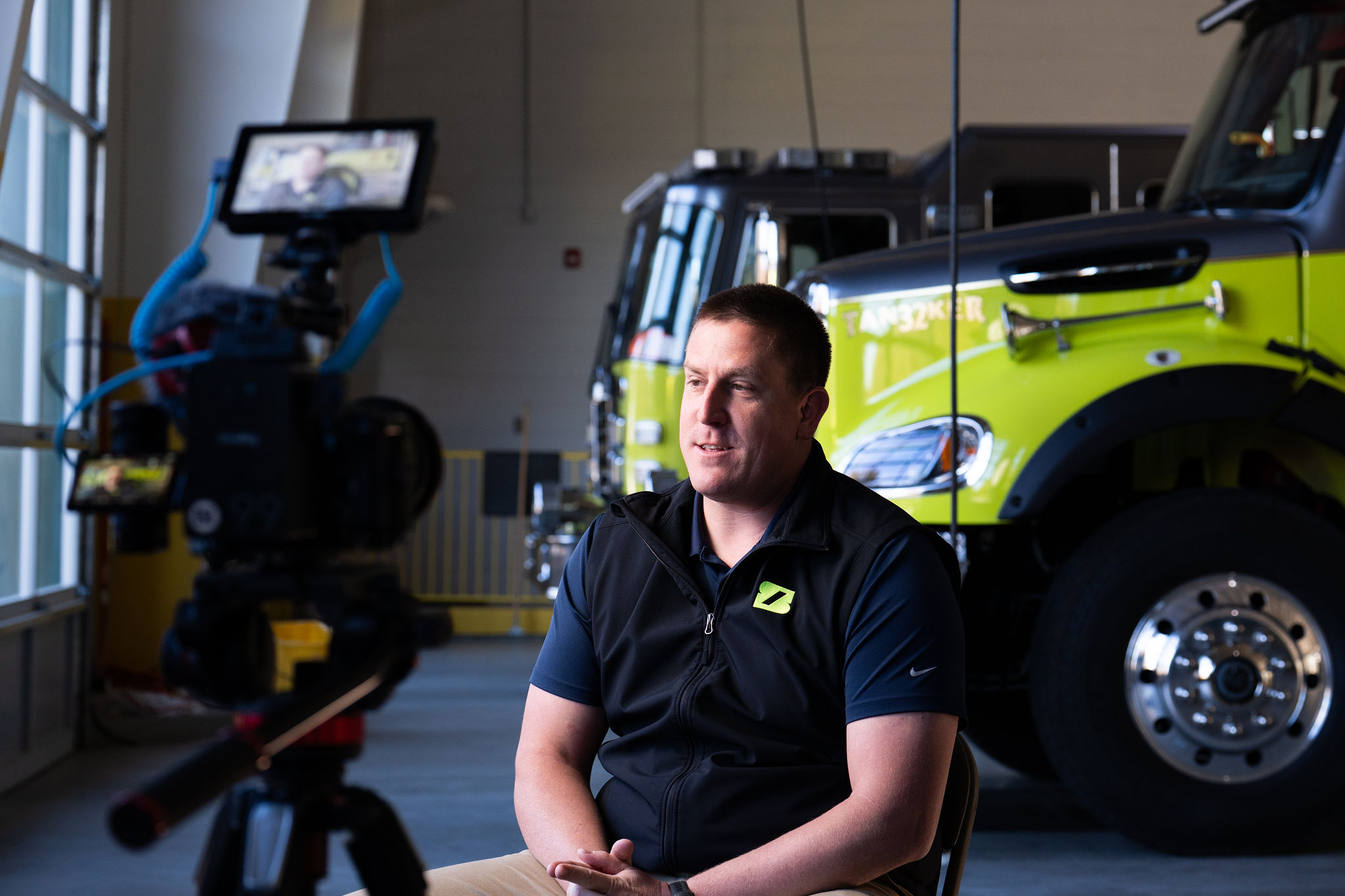 A teammate interviewed in front of a lime green tanker